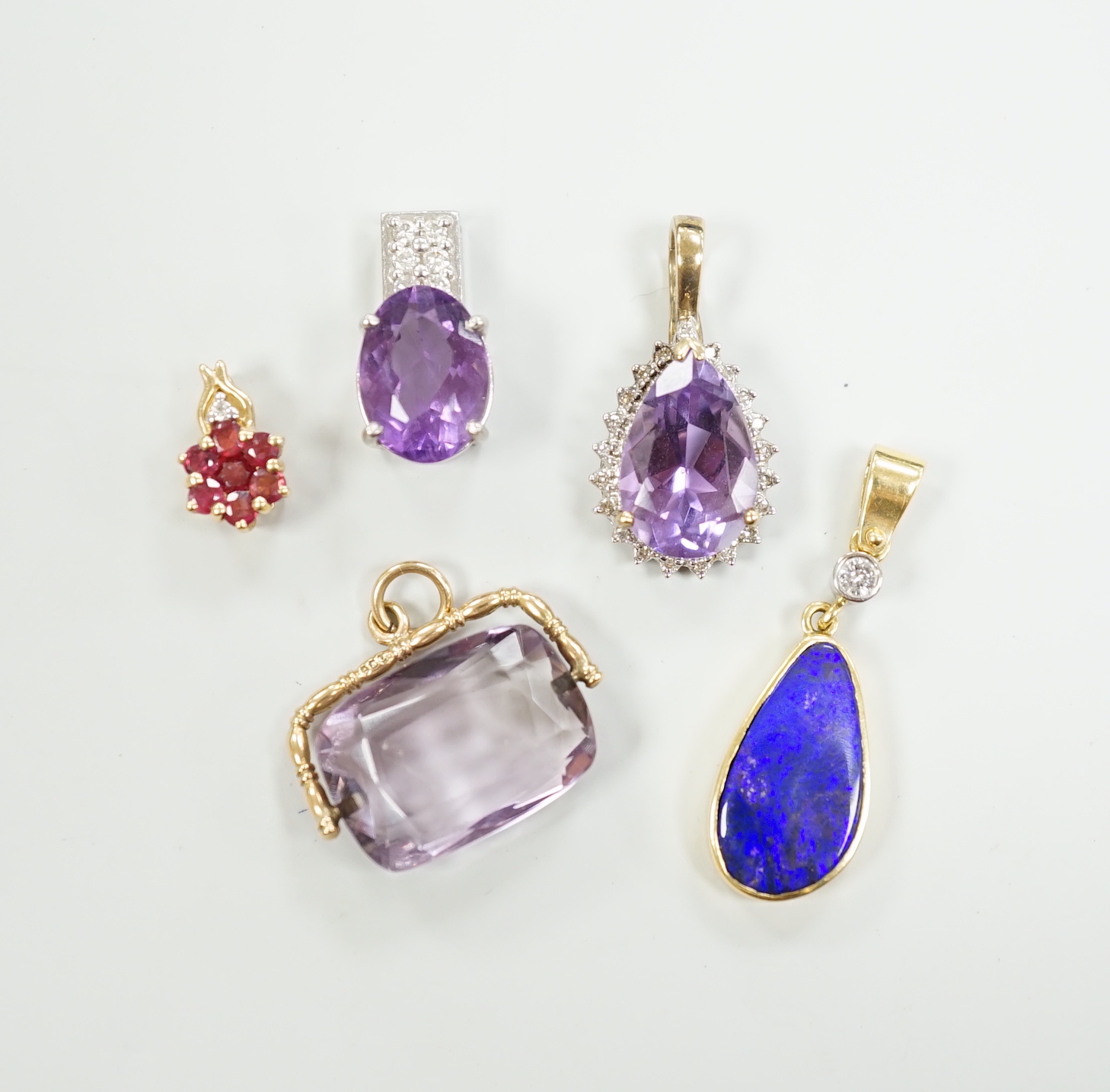 A white metal, stamped PT900, amethyst and diamond cluster set pendant, 18mm, gross weight 5.5 grams and four other pendants including three 9ct and gem set and a yellow metal and simulated opal and diamond, gross 13 gra